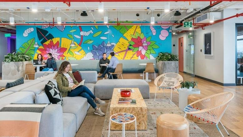 Spacious communal lounge at Ac. Calle 100, 11b, Bogota with a vibrant floral mural and comfortable seating.