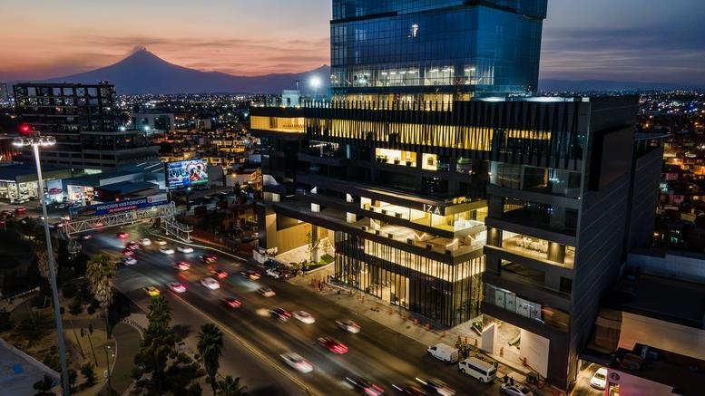 Evening exterior view of the glass-facade Atlixcáyotl 2210 building at sunset.