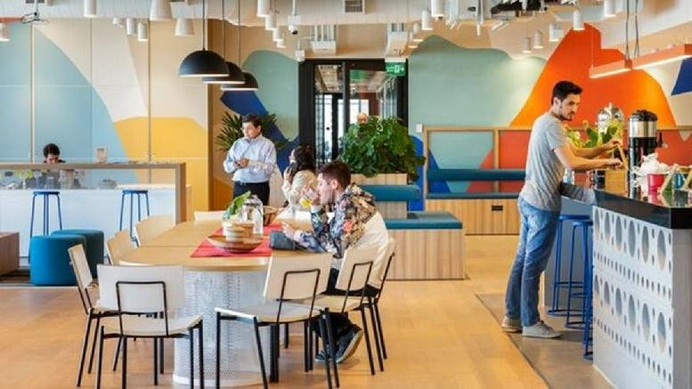 Lively coworking space at Av. Almirante Silvio de Noronha, 365 featuring colorful murals and a central dining table.