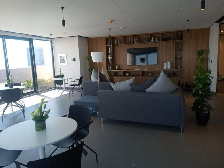 Spacious communal lounge at Av. Insurgentes Sur 64, Colonia Juárez with plush sofas and large windows.