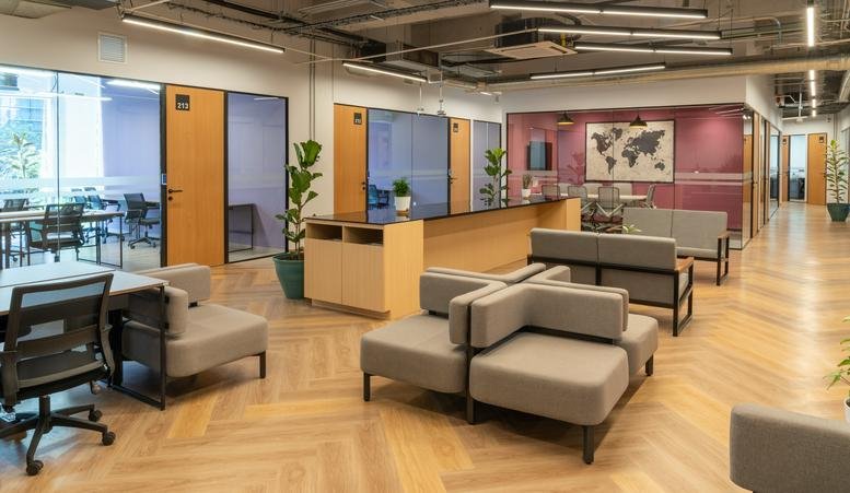 Spacious communal lounge at Av. Insurgentes Sur 866 with gray modular sofas and wood floors.