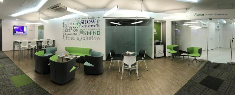 Spacious lounge at Av. Paseo de la Reforma 215 with colorful green chairs and wall graphics.