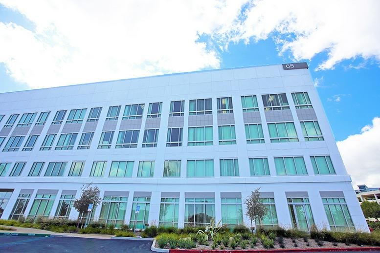 Exterior view of the white multi-story building at 65 Enterprise, Suite 400, Aliso Viejo.