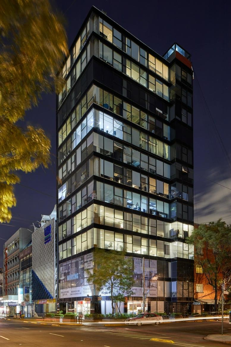 Evening exterior view of the modern glass-facade building at Avenida Chapultepec, No. 480, Mexico City.