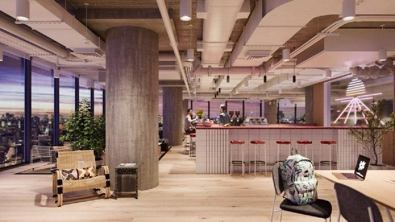 Spacious coworking lounge at Avenida Corrientes 800 with floor-to-ceiling windows and exposed ceilings.