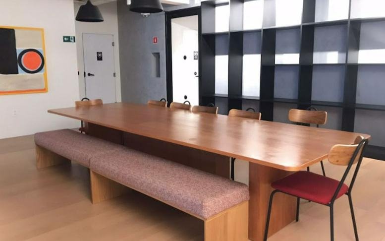 Bright dining area at Market Place featuring a long wooden table and bench seating.