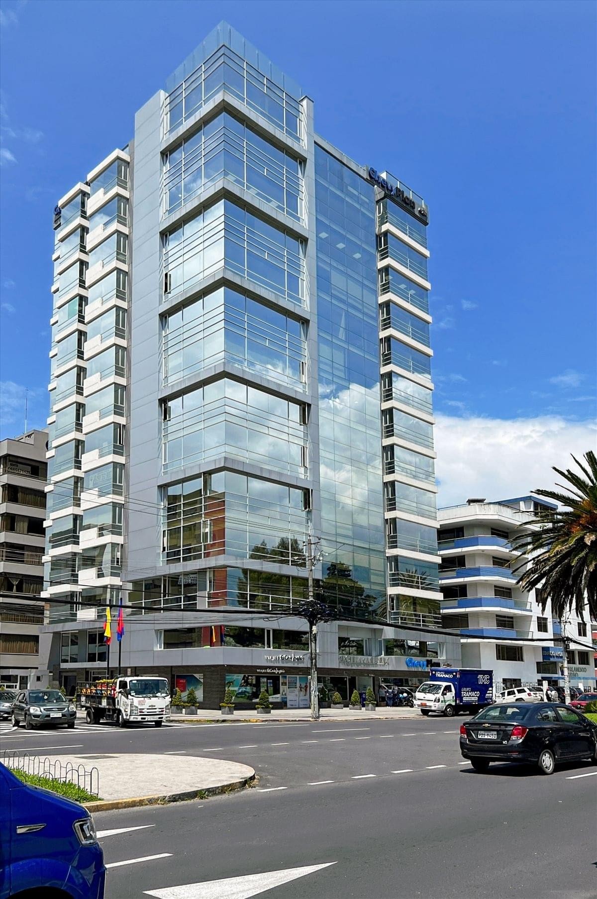 Exterior view of the modern glass-facade building at Avenida Eloy Alfaro E6-24.
