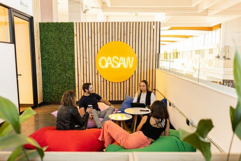 Bright communal lounge at Avenida los Carreras Poniente 301 with bean bags and a decorative plant wall.