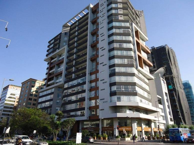 Exterior view of the multi-story Edificio Cosmopolitan with modern glass and wood accents.