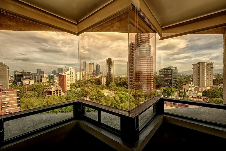Exterior view of the tall, angular glass building at Avenida Presidente Masaryk 101.