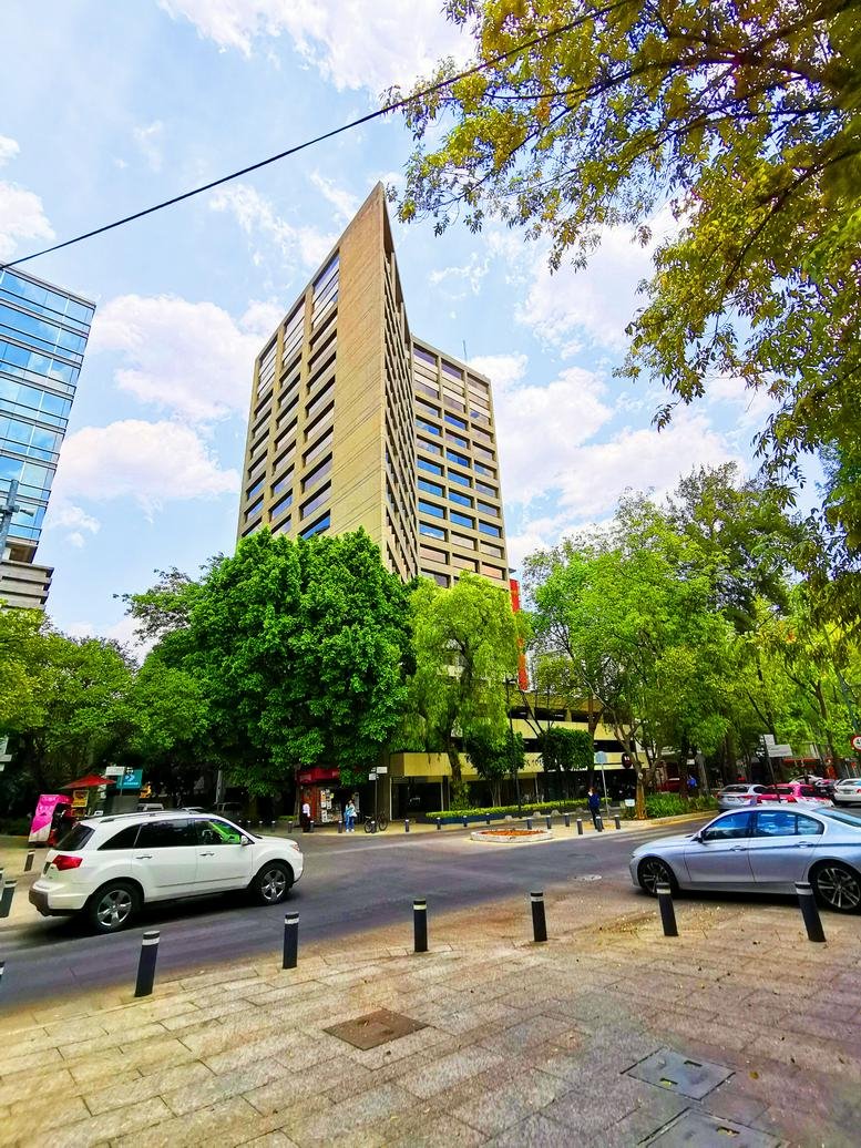 Exterior view of the tall, angular tan building at Avenida Presidente Masaryk 101.