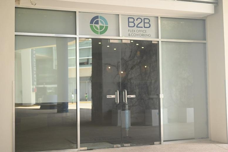 Main glass entrance at Avenida Sayil Manzana 1 Lote 4-07 SM 4A Zona Centro showing the B2B logo.