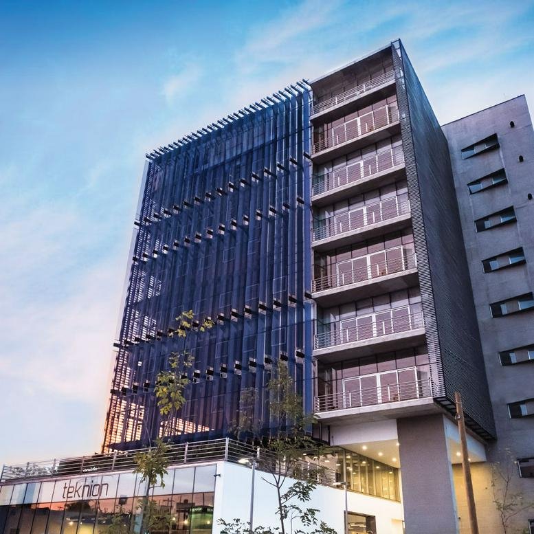 Exterior view of the modern glass and concrete building at Avenue Patria 888 Jardines Universidad, Zapopan.