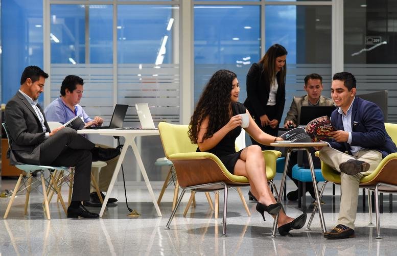 People working and socializing in a vibrant communal lounge area at Boulevard Adolfo Ruiz Cortines 1344.