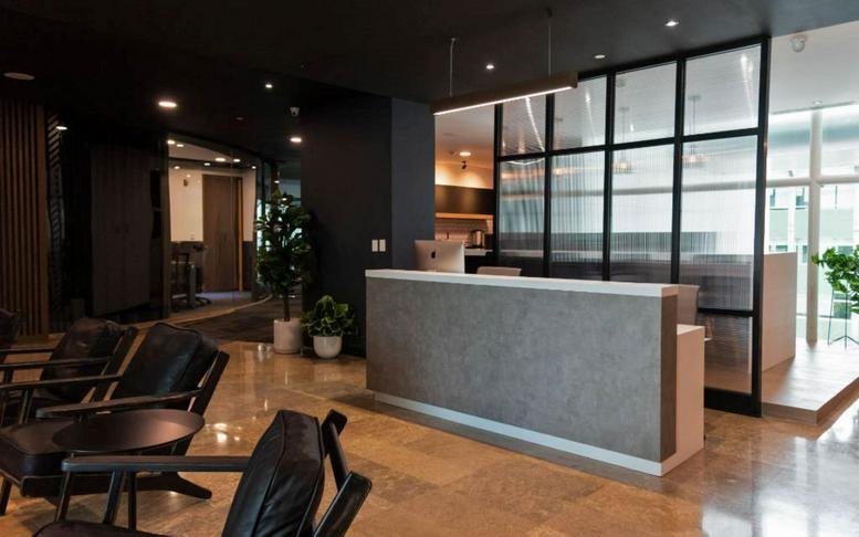 Modern reception area at Boulevard Díaz Ordaz 123 featuring a sleek grey desk and warm lighting.
