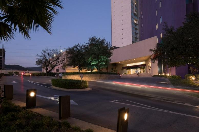 Evening exterior view of the entrance at Las Torres Moradas Torre 2 with tree-lined driveway.