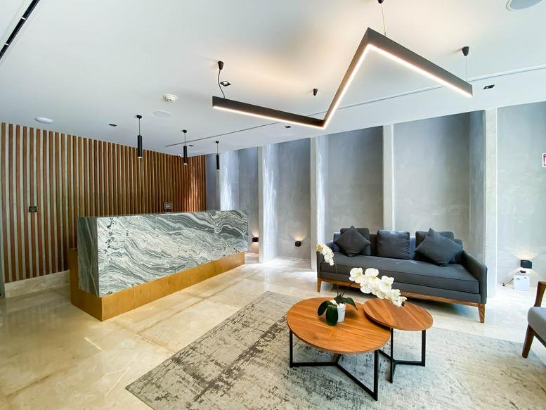 Modern lobby for Calle 20 No. 438, Colonia México, Merida featuring a marble desk and zigzag light fixture.