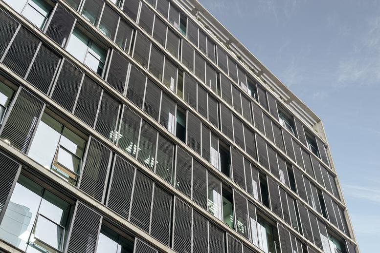 Exterior view of the modern glass and slatted facade at Calle Recavarren 111.