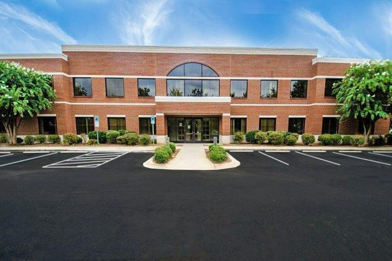 Exterior brick facade and entrance of the (CHA) 6047 Tyvola Glen Circle building under a blue sky.