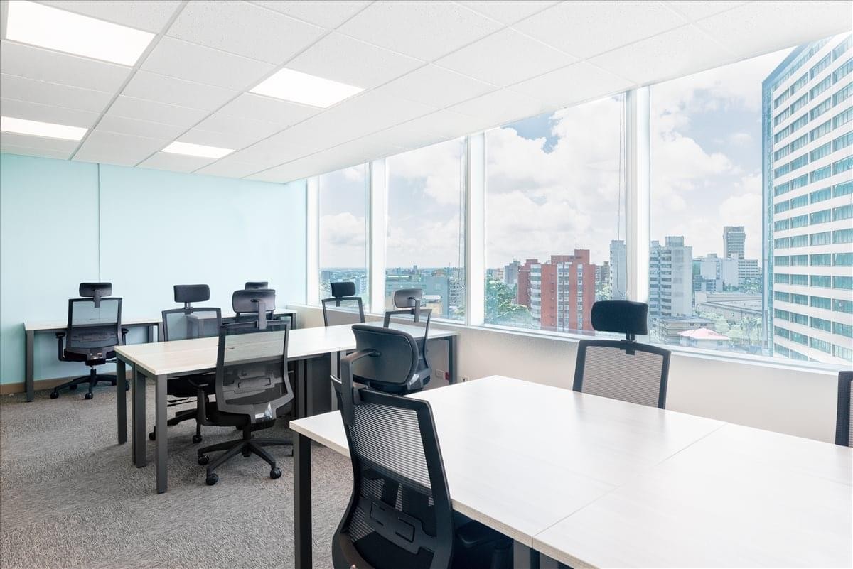 Bright coworking space at Cl. 77B No. 57-103 Barranquilla with multiple desks and city views.