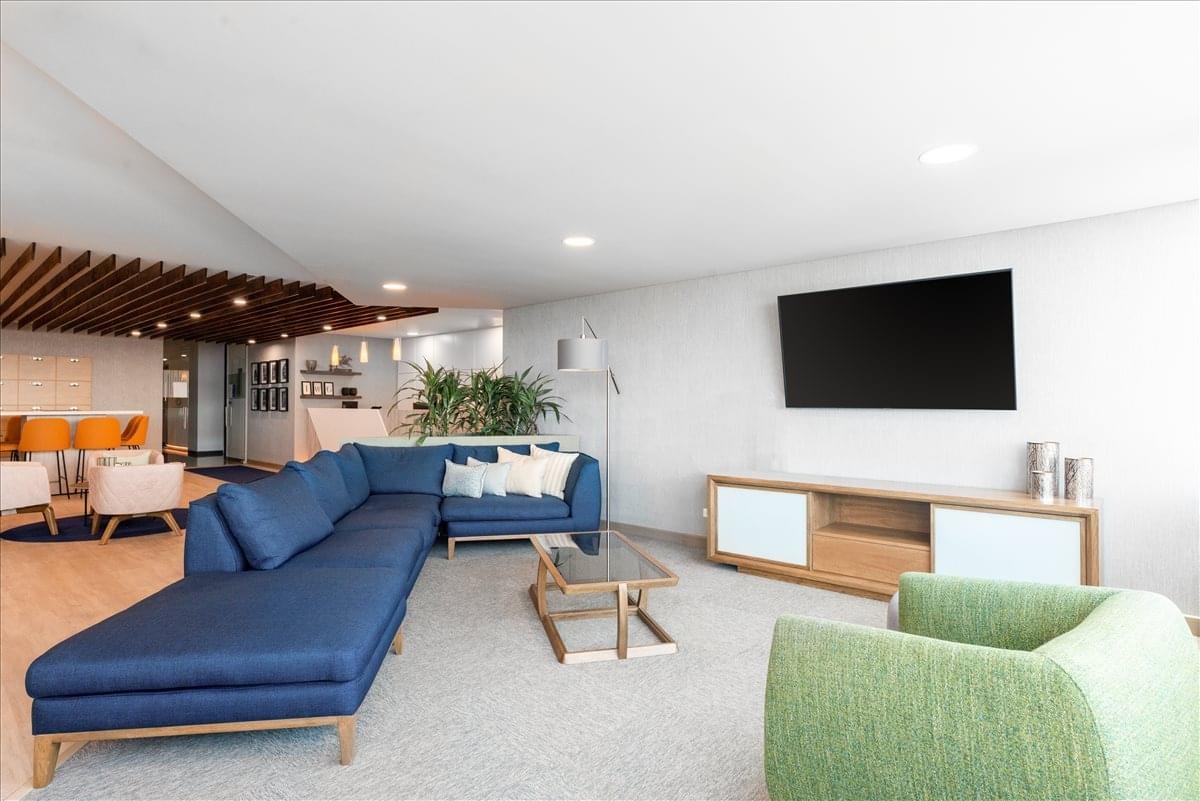 Lounge area at Cl. 77B No. 57-103 Barranquilla with a large blue sectional and modern furnishings.