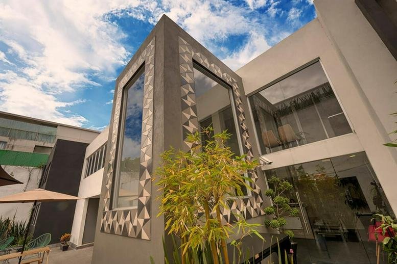 Modern building exterior with large glass windows and geometric tile patterns.