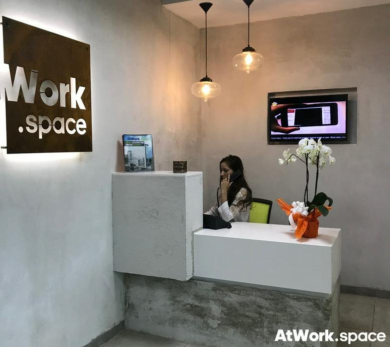 Reception area at Edificio Insigne with branded signage and white front desk.