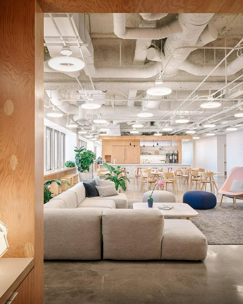 Spacious communal lounge at Equitable Plaza, 3435 Wilshire Boulevard with modular seating and industrial ceiling.