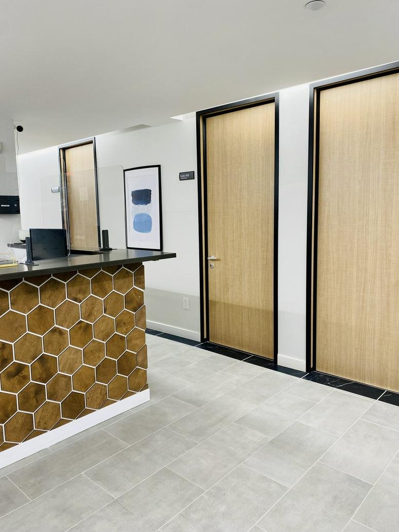 Reception area at Grand Central, 353 Lexington Avenue featuring a wooden honeycomb feature wall and light tile floor.