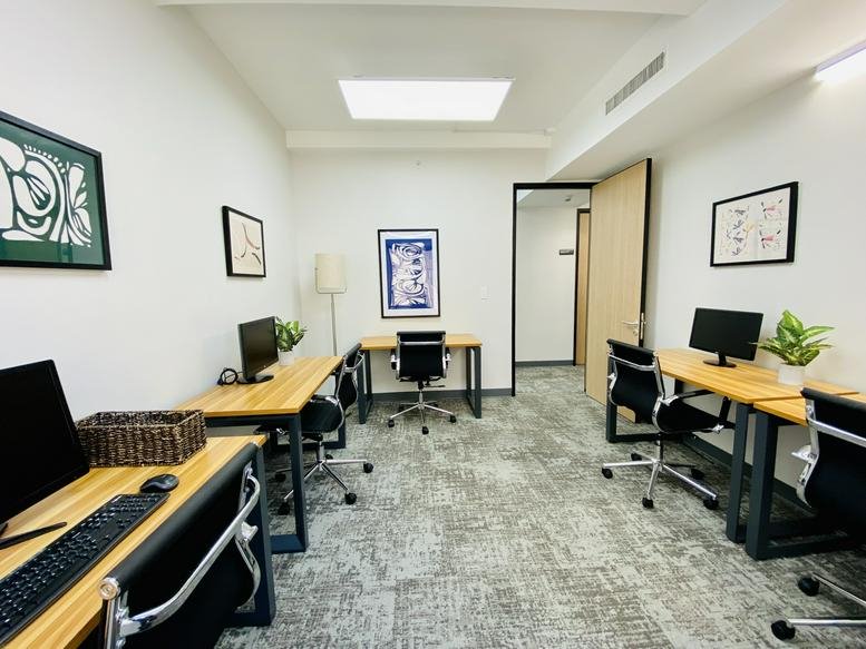 Spacious team office at 353 Lexington Avenue with four desks, framed art, and natural light.