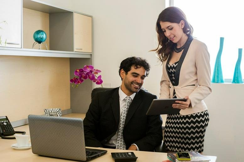 A man and woman collaborating over a tablet in a bright office at Hotel Holiday Inn, Boulevard Hermanos Serdán No. 45.