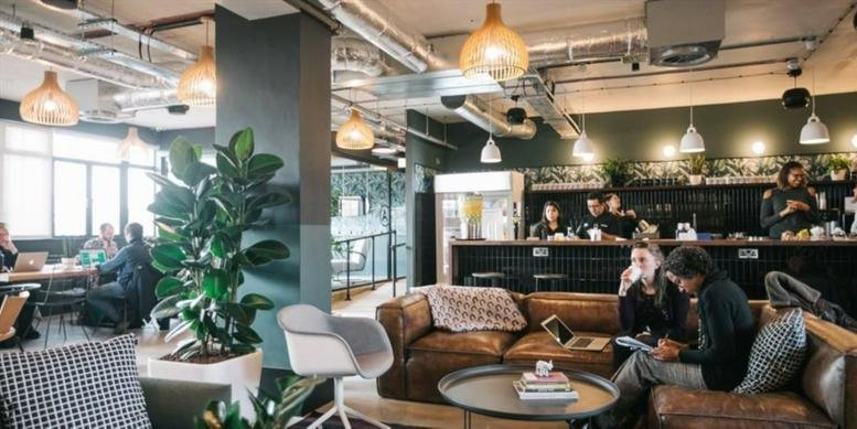 Spacious communal lounge at Ing. Enrique Butty 275, Buenos Aires with leather sofas and warm lighting.