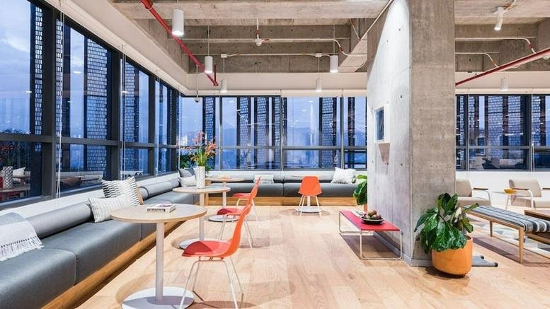 Bright coworking area with large windows and varied seating