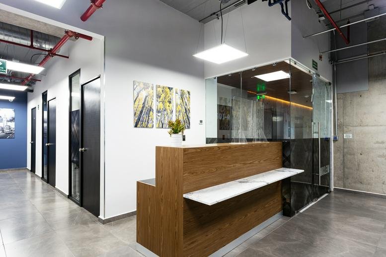Modern reception area with a wood-panelled desk and branded glass partition at Lago Alberto No. 442, Torre A, Piso 5.
