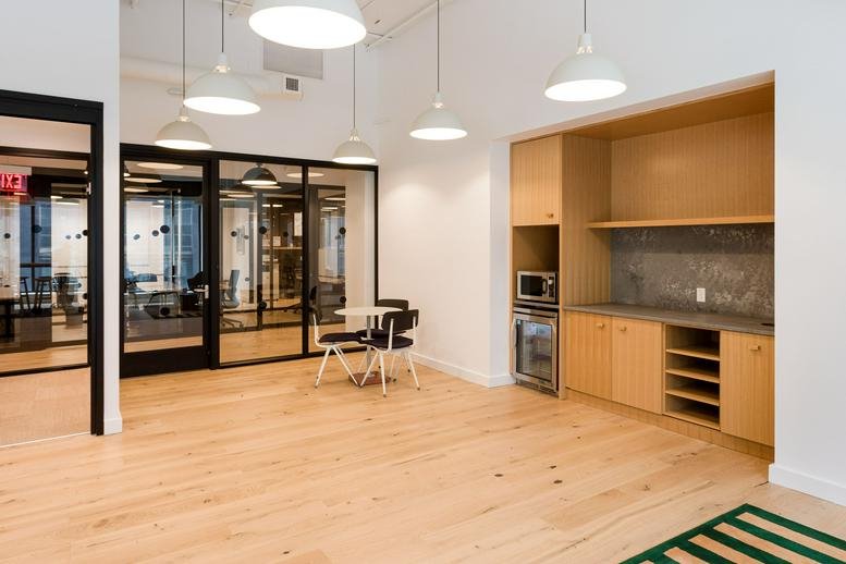 Communal kitchen area with light wood floors and integrated cabinetry at Lightwell, 1100 Main Street.