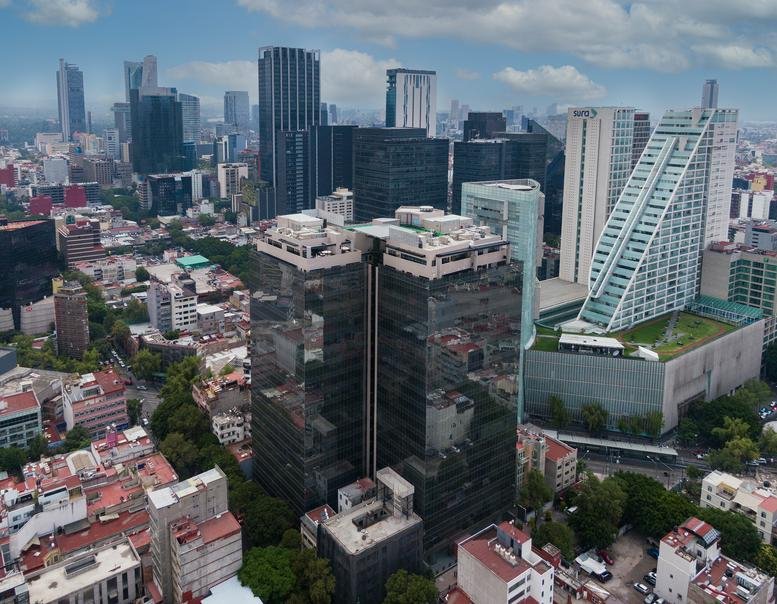 Exterior view of the dark glass facade and unique architecture of Londres 61, Col. Juárez.