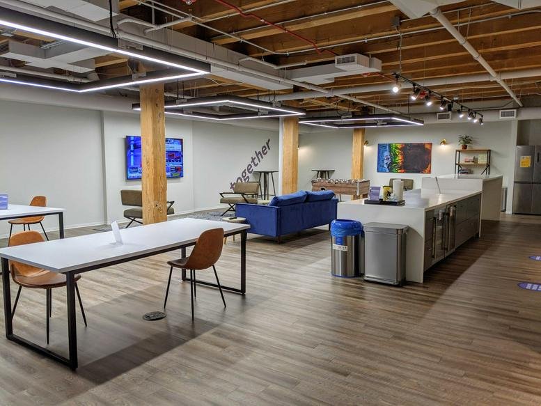 Spacious communal lounge at Magnificent Mile, 420 North Wabash Avenue with a kitchen and wood-beamed ceilings.