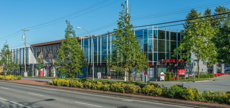 Exterior view of the modern glass facade building at No. 202 15388, 24 Avenue.