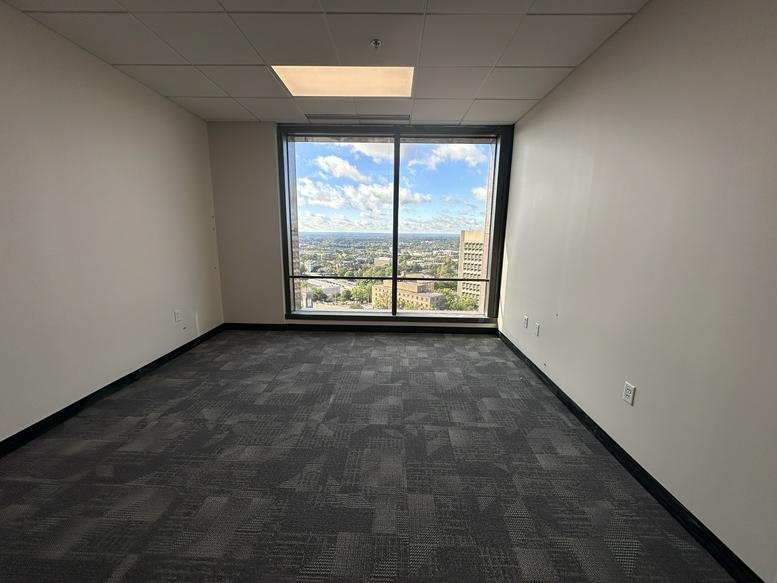 Private corner office featuring large windows with an expansive city view.