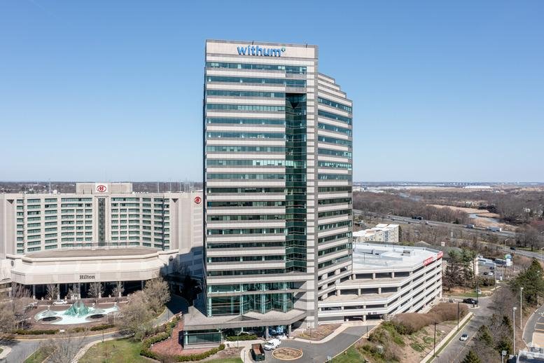 Exterior view of the multi-story tower at 1 Tower Center Blvd under a clear blue sky.