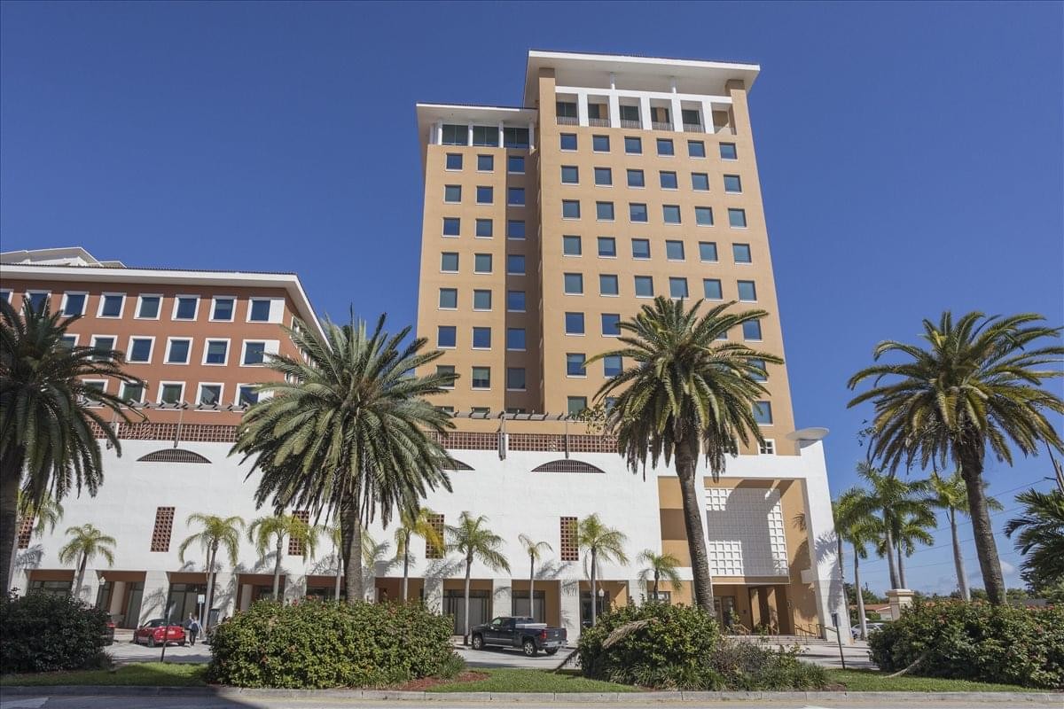 Exterior view of the Mediterranean-style 1 Alhambra Plaza building under a clear blue sky.