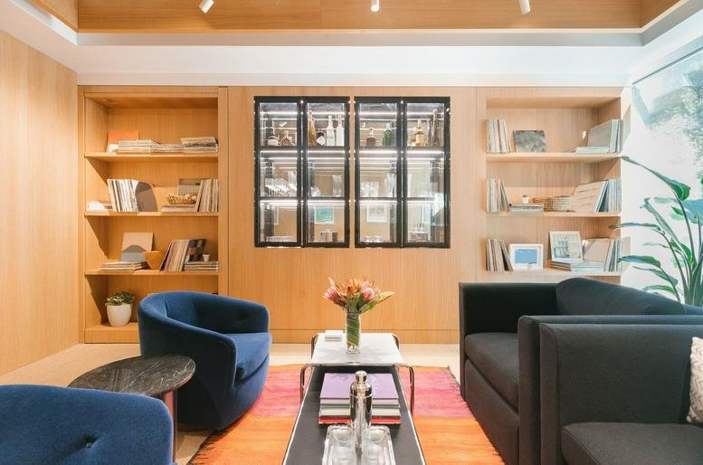 Bright, modern communal lounge at 1 Belvedere Drive, Mill Valley, CA, California with colorful rugs and blue armchairs.