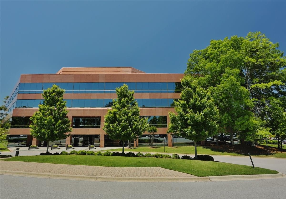 Exterior view of the multi-story 1 Chase Corporate Center with manicured lawn and mature trees.