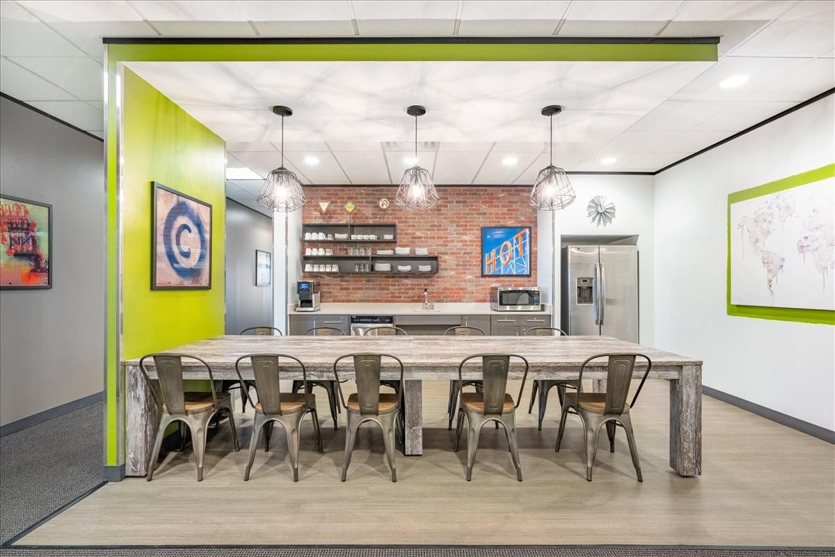 Communal kitchen and break area at Old Town Square, Suite 450, 1 Chisolm Trail Road with a long wooden dining table.