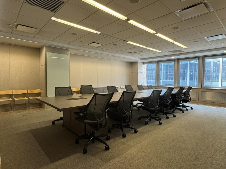 Spacious boardroom with a long wooden table and ergonomic chairs at THE HUB, Church Street, New York City.