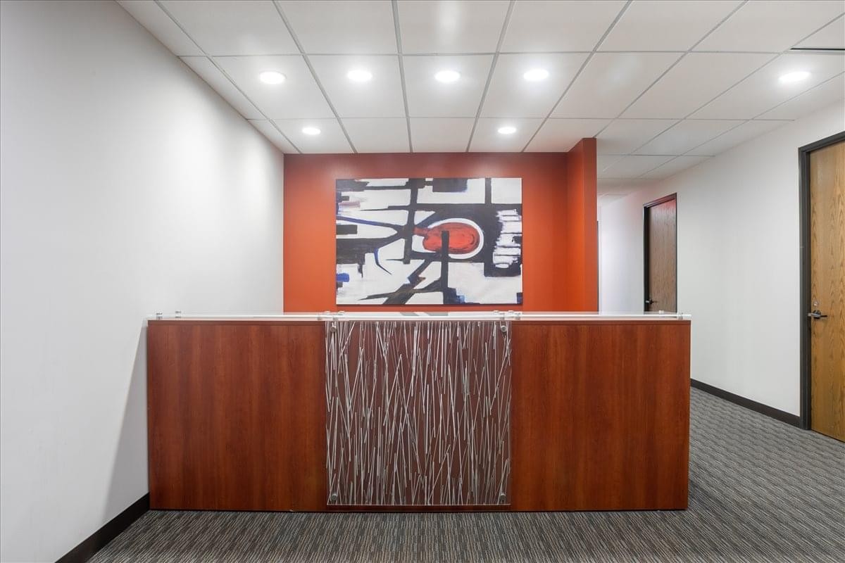 Reception area at Crosswoods Center with a wood-panelled desk and abstract art.