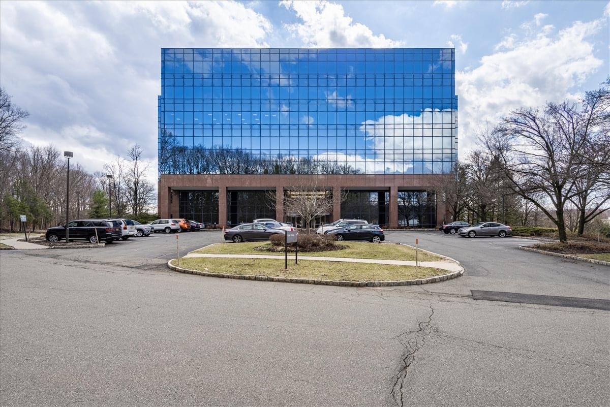 Exterior view of the blue glass-facade building at 100 Enterprise Drive, Suite 301.