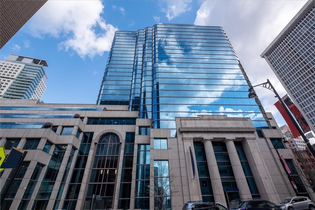 Low-angle exterior view of the blue glass skyscraper at 100 Pearl Street.