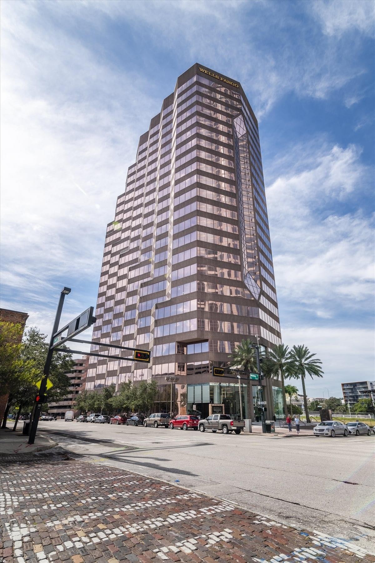 Exterior view of the multi-tiered glass and stone skyscraper at 100 S. Ashley Drive.