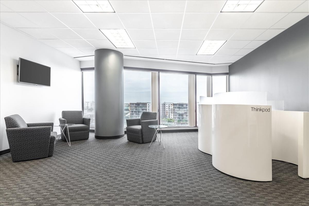 Bright lobby area with curved white reception desk and city views.